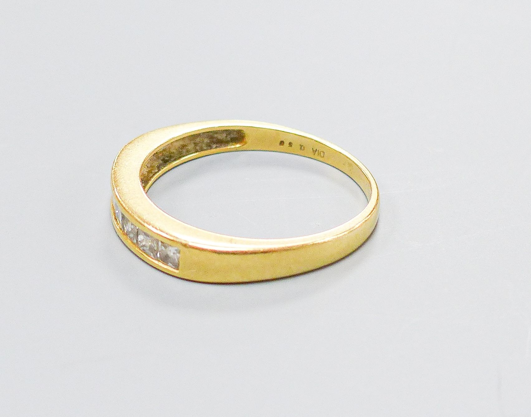 A modern 18ct gold and channel set seven stone diamond half hoop ring, size P, gross weight 2.8 grams.